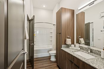 A bathroom with a toilet, sink, and mirror